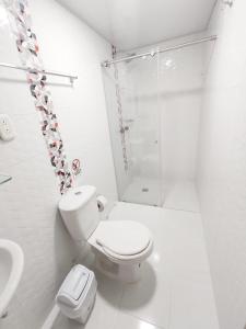 a white bathroom with a toilet and a shower at Hotel Casablanca Cañaveral in Floridablanca +10 photos