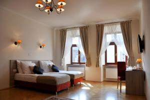 a bedroom with a bed and two windows at Hotel Santi in Kraków