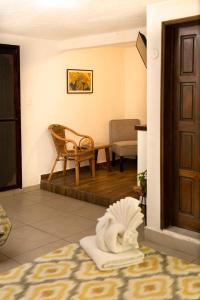 Habitación con puerta, silla y estatua en Hotel Amar Inn en Puerto Morelos