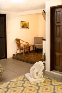 Habitación con puerta, silla y estatua en Hotel Amar Inn, en Puerto Morelos