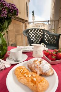 a white plate with pastries and strawberries on a table at Leccesalento Bed And Breakfast in Lecce