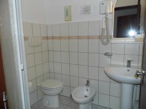un piccolo bagno con servizi igienici e lavandino di Lina Hotel a Stintino