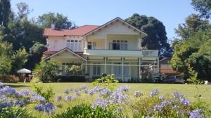 a house with purple flowers in the yard at Arles Historical Homestead in Whanganui +12 photos