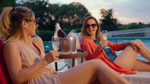 two women sitting at a table with glasses of wine at Interludium Iguassu Hotel by Atlantica in Foz do Iguaçu