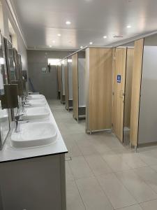a row of sinks in a public restroom with stalls at Broken Hill Tourist Park in Broken Hill