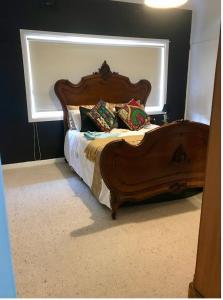 a bedroom with a wooden bed with a window at Parker st in Cootamundra +2 photos