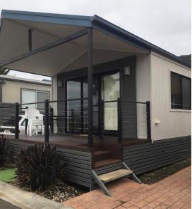 a house with a large deck with a patio at Beach Cabin Apollo Bay in Apollo Bay