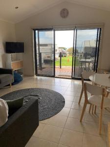 uma sala de estar com um sofá e uma mesa em Beach Cabin Apollo Bay em Apollo Bay