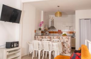 uma cozinha com uma mesa e cadeiras brancas num quarto em La Plage Salvador - Boutique Hostel em Salvador