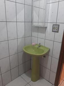 a green sink in a bathroom with white tiles at Apartamento mobiliado no Canto do Forte - Praia Grande - SP Férias, temporada, feriados in Sao Paulo