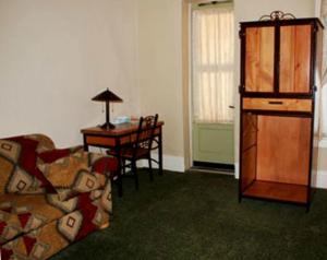 a living room with a couch and a desk and a table at Hotel Eklund in Clayton