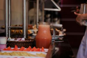 a pitcher of orange juice next to a plate of watermelon at Hotel Biton in Foz do Iguaçu