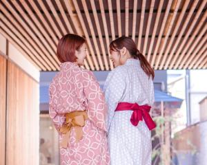 twee vrouwen in kimono's die naast elkaar staan bij Hotel Imagine Kyoto in Kyoto