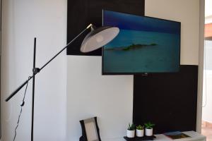 escritorio con lámpara y TV en la pared en En Origen en Guaymallén