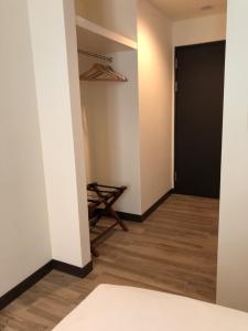 a hallway with a black door and wooden floors at Honest & Warm Hotel in Taoyuan