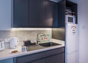 a kitchen with a sink and a refrigerator at The Studio @ 93 Bernard Rd in Brighton & Hove