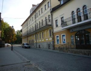 een auto geparkeerd in een straat naast een gebouw bij Апартаменти в Старому Місті Sweet House in Kamjanets-Podilsky