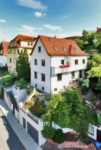 attraktives 2-Zimmer-Apartment mit Ausblick في جينا: مبنى ابيض بسقف احمر على شارع المدينة