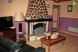 Maison de 2 chambres avec terrasse et wifi a Longvilliers في Longvilliers: غرفة معيشة مع موقد وأريكة