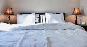 トビリシにあるAden Apartmentsの白いシーツと枕が備わった大きなベッド