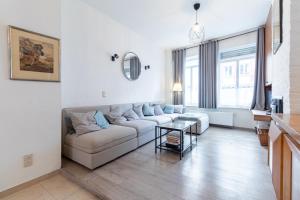 Una sala de estar con un sofá blanco y una mesa. en Bruges Holiday Home, en Brujas
