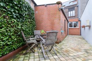 un patio con dos sillas y una mesa en Bruges Holiday Home, en Brujas