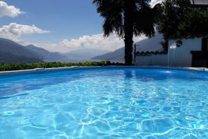 une grande piscine avec vue sur les montagnes dans l'établissement Amarone Classica, à Gravedona