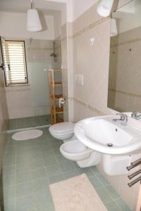 baño con 2 aseos y lavamanos en Jonico Guest house .. calabria, en Montegiordano