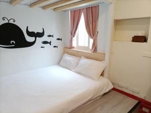 a bedroom with a whale stenciled on the wall at Kenting Good Homestay in Kenting