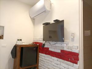 a tv on a brick wall in a room at Kenting Good Homestay in Kenting