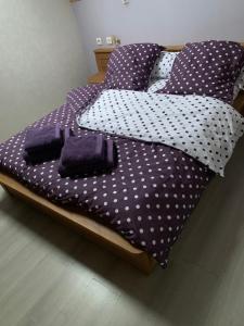 ein violettes Bett mit Bettwäsche und Kissen aus Polyka in der Unterkunft Fée maison with love appartement in Cuissai
