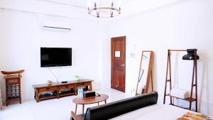 鐵花國小民宿 في مدينة تايتونج: غرفة معيشة مع أريكة وتلفزيون