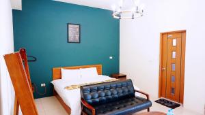 Un dormitorio con una cama y una silla de cuero negro en 鐵花國小民宿, en Taitung