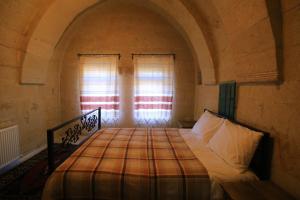 a bedroom with a bed in a room with windows at DIADEM CAPPADOCIA GUEST HOUSE & HOSTEL in Göreme
