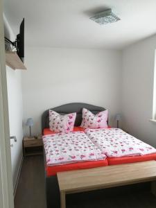 a bedroom with a bed with pink pillows on it at Strandläufer in Gelbensande