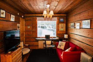 a living room with a red couch and a television at Poppelstrand Nuuksio, Pet friendly guest apartment in Nuuksio
