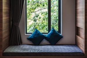 twee blauwe kussens voor een raam bij VIX Bangkok at Victory Monument in Bangkok