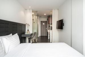 een slaapkamer met een bed, een bureau en een televisie bij VIX Bangkok at Victory Monument in Bangkok