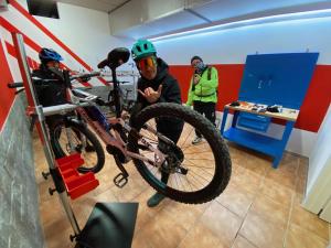 two men are working on a bike in a room at Impero Hotel Beauty & Spa - Bike Hotel in Cantello