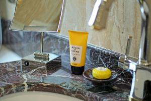 a bathroom sink with a bottle of soap and a cake at Orion Hotel Bishkek in Bishkek +31 photos