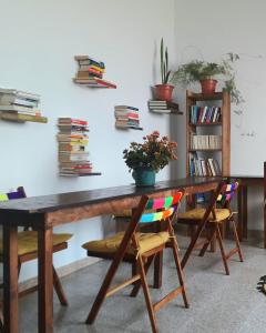een houten tafel met stoelen en boeken aan een muur bij Hostel Vagamundo in Los Llanos de Aridane
