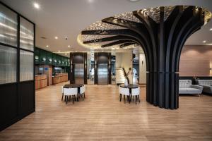 a lobby with tables and chairs in a building at VIX Bangkok at Victory Monument in Bangkok