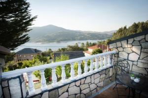 a balcony with a view of the water at Casa Blanco Vista Maravillosa in Compostela