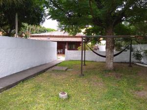 une balançoire installée dans une cour à côté d'un arbre dans l'établissement Casa para temporada em Cabo Frio, à Cabo Frio