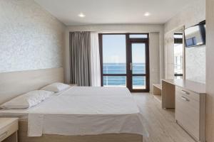 a bedroom with a bed and a view of the ocean at Sun Ray in Yalta