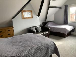 a bedroom with a bed and a chair in a attic at Rivington House Room only in Whitby