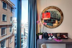 a room with a desk with a mirror and a window at Hotel Indigo Madrid - Gran Vía by IHG in Madrid