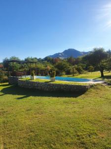 a stone retaining wall in a grassy field at misky wayra in Capilla del Monte