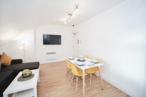 a living room with a table and yellow chairs at Canterbury 2 Bed Apartment Close to Town CT1 Sleeps 6 in Canterbury