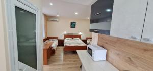 a room with two beds and a tv in it at Fema Guest House in Balchik